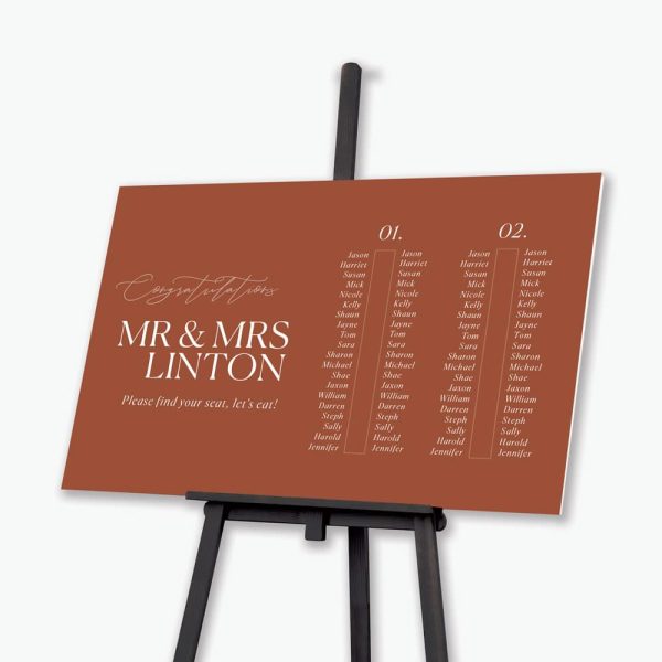 Colour block rust wedding seating plan on black easel