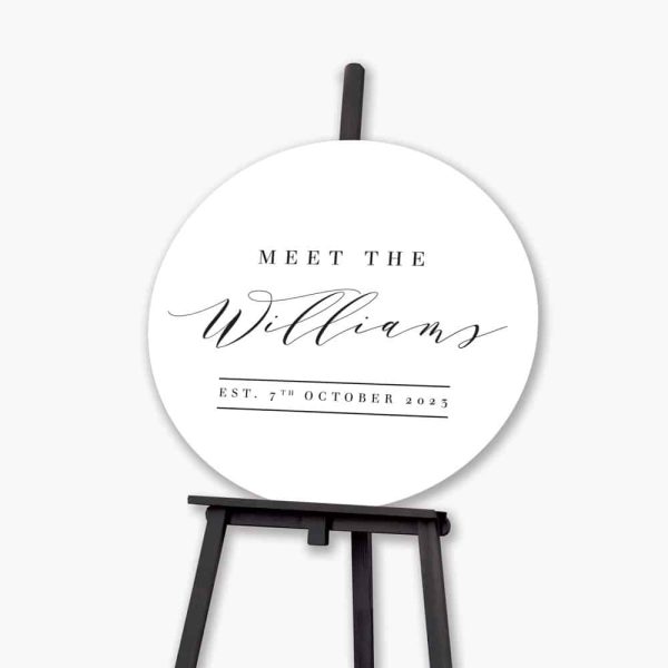 timeless round welcome sign sitting on black easel