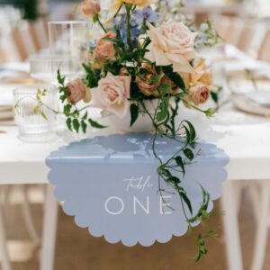 scalloped blue table number hanging off the edge of a table