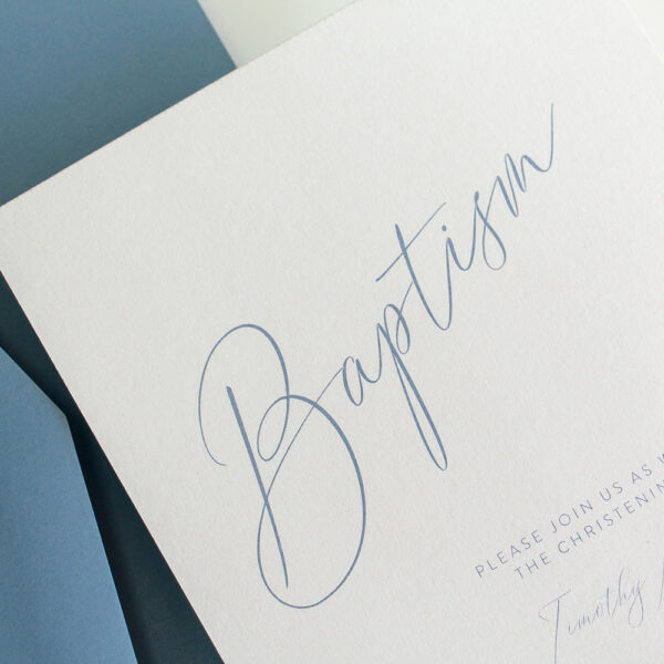 A baptism invitation with simple cursive writing and envelope